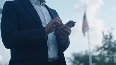 İş iletişimi. Mesajlaşma ve mesajlaşma. İş adamı dışarıda telefonla konuşuyor. Telefon kullanan bir işadamı, kopyalama alanı. Takım elbiseli adam telefonda konuşuyor. Telefonu olan bir iş adamı, kırpık manzaralı..