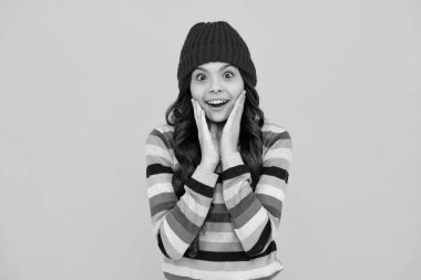 Winter hat. Cold season concept. Winter fashion accessory for children. Teen girl wearing warm knitted hat. Happy teenager, positive and smiling emotions of teen girl