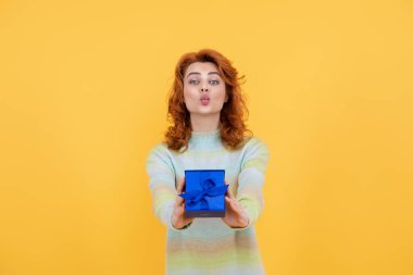 Anneye hediye. Tatiller, hediye kutlaması ve kadın konsepti. Doğum gününü kutlayan ve hediye alan romantik bir kızın portresi. Sürpriz kadının elinde özel bir geçmiş var.