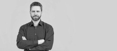 Kendine güvenen bir adam günlük gömlek giyer kolları çapraz gri arka plan, resmi olmayan kıyafetler, fotokopi alanı. İnsan yüzü portresi, kopyalanmış pankart