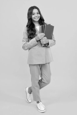 Genç liseli kız kitaplarla ders çalışıyor. Bilgi ve çocuk eğitim konsepti öğrenme