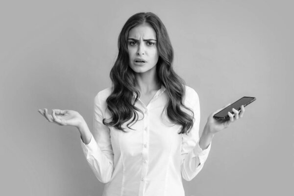 Upset sad woman with smart phone. Young woman with mobile phone. Businesswoman with smartphone on grey background