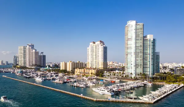 Lüks yatları ve tropikal gökdelenleri olan Miami marinasının havadan görünüşü. Miami kıyısı kıyısı. Miami marinası ve turkuaz okyanusta yelkenliler ve yatlar. Miami 'de lüks yolcu gemisi