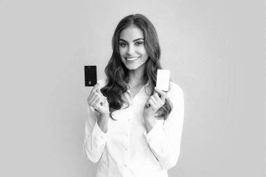 Woman holds template mockup bank credit card with online service isolated on gray background. Happy attractive young girl showing credit