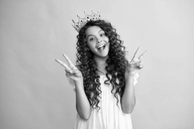 Genç bencil kız başarıyı kutluyor. Kraliçe tacındaki genç çocuk mavi arka planda izole edilmiş. Tacın içindeki prenses. Balo partisi. Mutlu ergen, pozitif ve gülümseyen genç kız duyguları