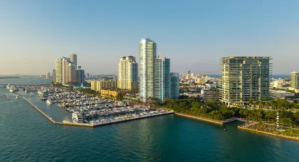 Lüks yatları ve tropikal silueti olan Miami sahilinin havadan görünüşü. Miami kıyısı kıyısı. Sakin bir marina ve turkuaz okyanusta yelkenliler ve yatlar. Lüks yolcu gemisi
