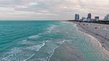 Plajın tadını çıkarıyorum. Yaz tatili. Yazın deniz kenarında tatil. Deniz dalgaları. Denize açılın, rahatlayın. Turkuaz suyla havadan kumlu kumsal. Lüks tatil köyü. Miami plajı.