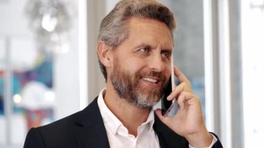 Telefon kullanan bir iş adamı. Takım elbiseli bir adam telefonda konuşuyor. Telefonu olan olgun bir İspanyol iş adamı. İş iletişimi. Müzakere çevrimiçi. İş adamı telefonda konuşuyor..
