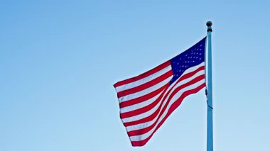 Rüzgarda dalgalanan Amerikan bayrağı. ABD bayrağı. Ulusal bayrak sallayarak mavi gökyüzünde Birleşik Devletler. Bağımsızlık Günü. Vatanseverlik sembolü. Anma Günü için Amerikan Bayrağı ya da 4 Temmuz. İşçi Bayramı.
