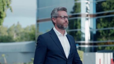 Dışarıda başarılı bir iş adamı. Şehir caddesinde yürüyen bir adam. Takım elbiseli bir iş adamı. İş adamının iş başarısı. Başarıya giden yol. Takım elbiseli adam ofise yürür. İspanyol işadamı ofis binasında..