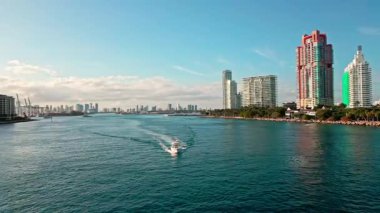 Lüks bir yat. Miami limanından ayrılan bir yat. Miami hava manzaralı. Lüks deniz ufku ve şehir manzarası. Miami marinası hava görüntüleri. Denizdeki sürat teknesi. Yaz tatilinde deniz tatili. Miami Liman Manzarası.