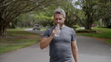 Susuz kalma. Susamış koşucu egzersizi. Susamış adam su içiyor. Sporcu adam susamış. Sağlıklı bir yaşam tarzı. Vücutta su dengesi. Sporcu adam susamış su içiyor. Elektrolit su dengesi.