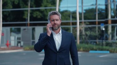 İş adamının telefon görüşmesi var. İspanyol işadamı telefon kullanıyor. İş görüşmesi. Lider işadamı telefonda konuşuyor. Pazarlıkta iş başarısı. Akıllı telefondan iş adamı konuşması.