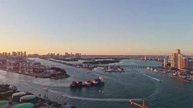 Miami, Florida, ABD - 28 Nisan 2025 Miami Limanı Günbatımı Hava Görüntüsü. Konteynırlı kargo iskelesi. Miami Limanı. Ticari nakliye. Miami limanı ve sahil gemisiyle şehir manzarası. Hava görünümü.