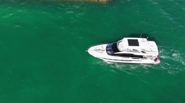 Lüks bir tekne denizde yüzüyor. Denizde yat. Lüks tekne, yat limanına gidiyor. Deniz gemileri. Tekne gezisi. Yat kulübü. Yaz tatilinde deniz tatili. Tekne ve yat kiralama. Yaz tatili.