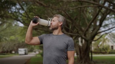 Sıvı yeterliliği. Antrenmandan sonra susamış koşucu. Susamış adam su içiyor. Sporcu adam susamış. Sağlıklı bir yaşam tarzı. Vücutta su dengesi. Sporcu adam susamış su içiyor. 4k görüntü.