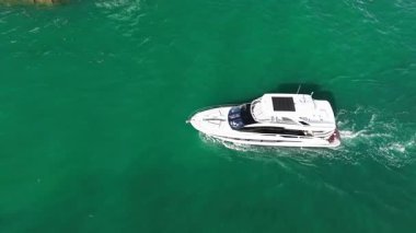 Tekne ve yat kiralama. Yaz tatili. Lüks bir tekne denizde yüzüyor. Denizde yat. Lüks tekne, yat limanına gidiyor. 4K görüntü. Tekne gezisi. Yat kulübü. Yaz tatilinde deniz tatili.