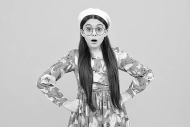 Şok olmuş ergen portresi sarı arka planda izole edilmiş. Şaşırmış genç kız. Şaşırmış yüz, şaşırmış genç kız duyguları.