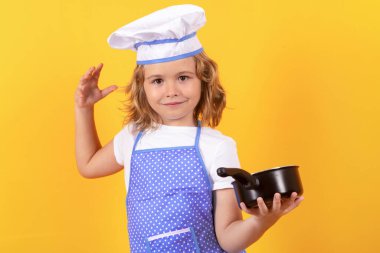 Mutfak saksısı olan komik aşçı çocuk. Aşçı üniformalı küçük bir çocuğun portresi. Şef çocuk stüdyo arka planında izole edilmiş. Aşçı olmak için sevimli bir çocuk. Aşçı şapkası giymiş bir çocuk.