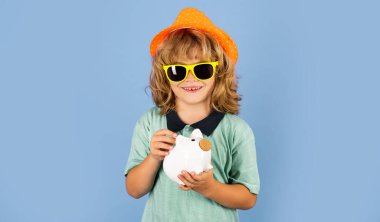 Tasarruf ve kumbara konsepti. Çocuk para biriktirmek için kumbaraya para koyuyor. Bozuk paralar ve çocuk konseptiyle domuz kumbarası