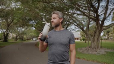 Susamış adam su içiyor. Sporcu adam susamış. Sağlıklı bir yaşam tarzı. Vücutta su dengesi. Sporcu adam susamış su içiyor. Uygun su dengesi. Susuz kalma. Çalışmadan sonra susamış koşucu.