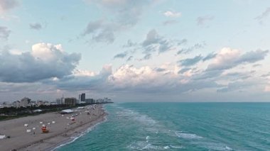 Denize açılın, rahatlayın. Turkuaz suyla havadan kumlu kumsal. Lüks tatil köyü. Miami plajı. Yaz tatili. Yazın deniz kenarında tatil. Deniz dalgaları. Güney Sahili titreşimleri.