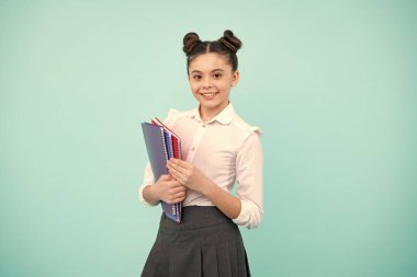 Kopya kitabı olan liseli kız izole edilmiş arka planda poz veriyor. Edebiyat dersi, ilkokul. Entelektüel çocuk okuyucusu. Mutlu ergen, pozitif ve gülümseyen genç kız duyguları