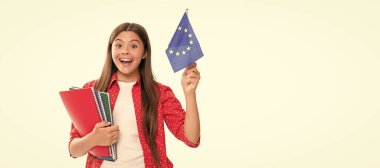 Yurtdışında okuyan hayret verici bir çocuk. seyahat et ve yabancı dil öğren. Genç kızda Avrupa Birliği bayrağı var. Öğrenci portresi, stüdyo afişi. Okul çocuğu yüzü, boşluklar