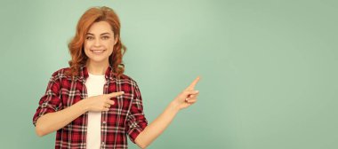 Mavi arka planda kareli tişörtlü, kızıl saçlı, gülümseyen bir kadın. İzole edilmiş yüz portresi, kopyalama alanı oluşturulmuş pankart