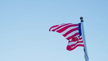 Bağımsızlık Günü. Vatanseverlik sembolü. Anma Günü için Amerikan Bayrağı ya da 4 Temmuz. Rüzgarda dalgalanan Amerikan bayrağı. ABD bayrağı gökyüzüne karşı. Mavi gökyüzünde Birleşik Devletler bayrağı sallıyor.