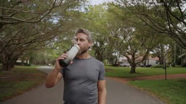 Sporcu adam susamış. Vücut suyu yönetmeliği. Vücutta su dengesi. Sporcu adam susamış su içiyor. Sıvı yeterliliği. Susuz kalma. Antrenmandan sonra susamış koşucu. Susamış adam su içiyor..