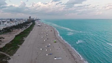 Lüks tatil köyü. Miami plajı. Rahatlamanın tadını çıkarıyorum. Yaz tatili. Yazın deniz kenarında tatil. Deniz dalgaları. Denize açılın, rahatlayın. Turkuaz suyla havadan kumlu kumsal. Kumsal kıyısı.