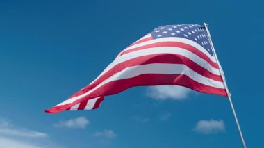 Bağımsızlık Günü. ABD, bağımsızlık ya da anma gününde gökyüzüne karşı bayrak sallayacak. Anma Günü 4K görüntüleri. Anma günü ya da 4 Temmuz için Amerikan bayrağı. Amerikan bayrağı vatanseverlik sembolü. ABD bayrağı.