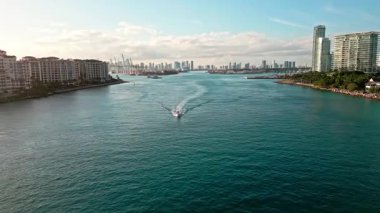 Miami limanı ve marina. Lüks marinalı Miami şehri. Lüks günbatımı manzaralı deniz marinası. Miami 'de Skyline. Manzaralı hava manzarası. Miami sahili manzarası. Hava görüntüsü. Motorlu tekne kanalı geçiyor.