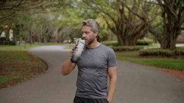 Sporcu adam susamış. Sağlıklı bir yaşam tarzı. Günlük su dengesi. Sporcu adam susamış su içiyor. Sıvı yeterliliği. Susuz kalma. Antrenmandan sonra susamış koşucu. Susamış adam su içiyor..