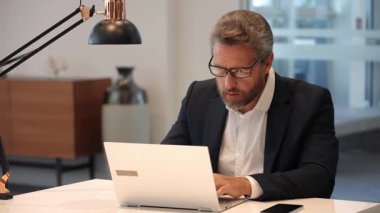 İş adamı başarısı. Serbest çalışan adam internette çalışıyor. Çevrimiçi çalışan serbest çalışan. Ofis çalışanı. Ofiste dizüstü bilgisayar kullanan kızgın bir adam. Serbest iş yapma. Erkek ofis yöneticisi. İş adamının internet işi var..