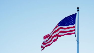 Rüzgarda dalgalanan Amerikan bayrağı. ABD bayrağı. Mavi gökyüzünde Birleşik Devletler bayrağı sallıyor. Bağımsızlık Günü. Vatanseverlik sembolü. Anma Günü için Amerikan Bayrağı ya da 4 Temmuz. Amerikan gururu.