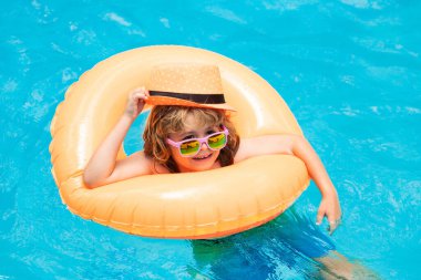 Yüzme havuzunda su sıçratan çocuk. Yaz tatilinde çocuklarla yüzme sporu aktivitesi