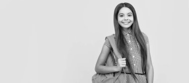 happy school child carry backpack on yellow background, school. Horizontal isolated poster of school girl student. Banner header portrait of schoolgirl copy space