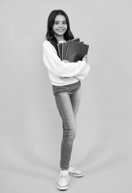 Genç liseli kız kitaplarla ders çalışıyor. Bilgi ve çocukların eğitim kavramını öğrenmek. Mutlu yüz, pozitif ve gülümseyen genç kız duyguları