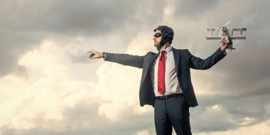 Yetişkin iş adamı takım elbiseli ve pilot şapkalı uçak fırlatma oyuncağı.