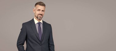 Gri saçlı, resmi takım elbiseli, karizmalı olgun bir lider. İnsan yüzü portresi, kopyalama alanı olan pankart