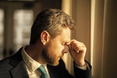 Ofiste başı ağrıyan stresli bir iş adamı. Yorgun iş adamı fazla mesai yapıyor ve başı ağrıyor. İş yerinde laptopla çok çalışan bir adam, baş ağrısı çekiyor. Aşırı çalışmaktan migrenim tuttu.