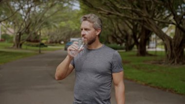 Sıvı yeterliliği. İç su dengesi. Antrenmandan sonra susamış koşucu. Susamış adam su içiyor. Sporcu adam susamış. Sağlıklı bir yaşam tarzı. Vücutta su dengesi. Sporcu adam içme suyu içiyor..