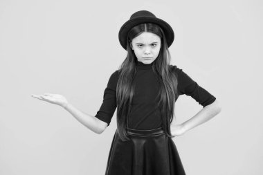 Close-up portrait of her she nice cute attractive cheerful amazed girl pointing aside on copy space isolated on yellow background. Angry face, upset emotions of teenager girl