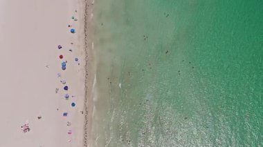 Deniz, plaj şemsiyesi altında rahatlar. Denize açılın. Kristal berrak turkuaz suyla kumsalın havadan görünüşü. Kumsalın tadını çıkarıyorum. Cennette yaz tatili. Yazın deniz kenarında tatil..