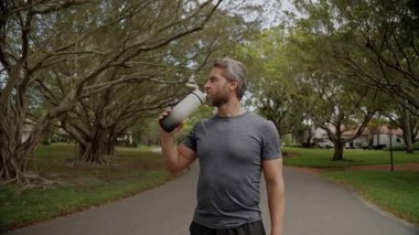 Sağlıklı bir yaşam tarzı. Vücutta su dengesi. Sporcu adam susamış su içiyor. Hidrasyon seviyesini koruyun. Antrenmandan sonra susamış koşucu. Susamış adam su içiyor. Sporcu adam susamış..