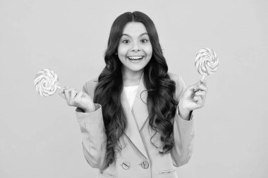 Sarı izole edilmiş arka planda lolipopu olan komik çocuk. Tatlı çocukluk hayatı. Lezzetli karamel lolipopu olan genç kız, şekerci. Mutlu ergen, pozitif ve gülümseyen genç kız duyguları