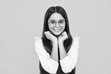 Happy girl face, positive and smiling emotions. Emotional portrait of caucasian teenager child girl isolated on studio yellow background
