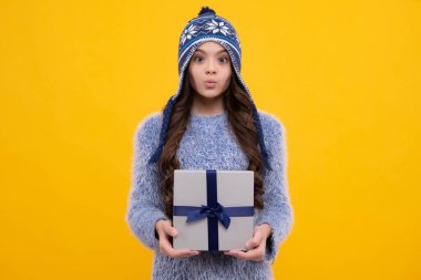 Yeni yıl ya da Noel hediyesi. Komik surat. Stüdyonun arka planında hediye kutusu olan çocuk. Çocukların doğum günü hediyesi.